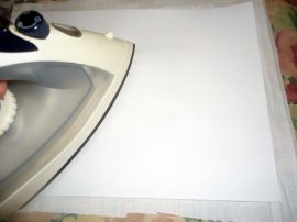 With shiny side down, iron the freezer paper to the fabric.